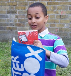 Boy opening the Letterbox Club blue parcel